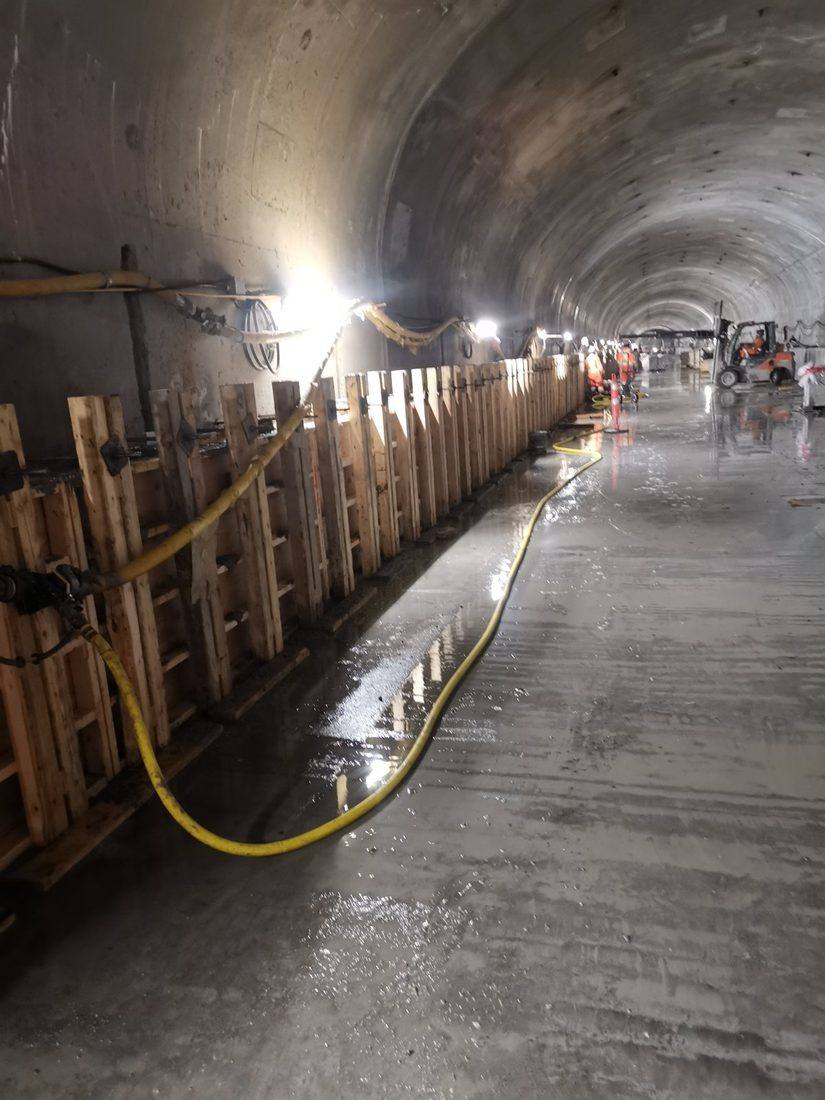 Coffrages alignés le long d'un tunnel en construction, boyau jaune au sol, sur un chantier de Martin Doyon