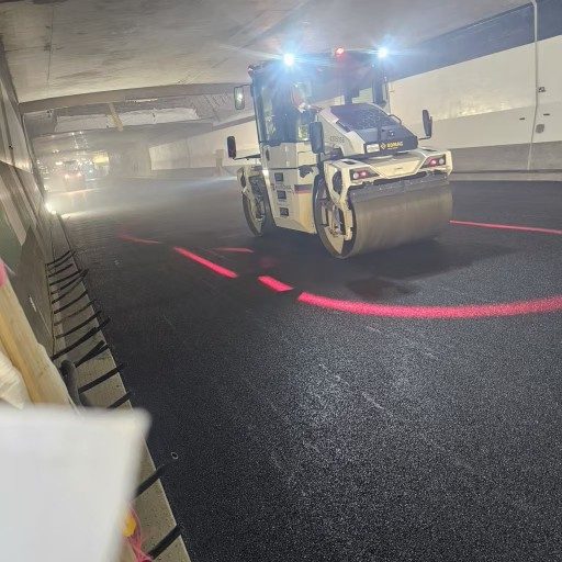 Rouleau compacteur posant l'asphalte dans un tunnel
